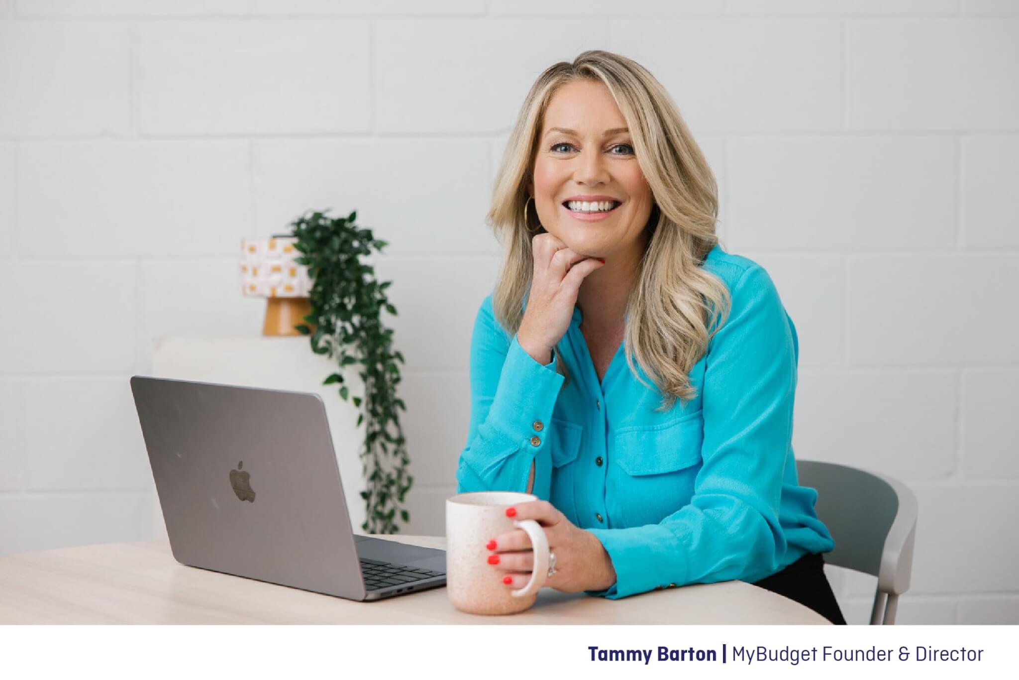 MyBudget Founder and Director, Tammy Barton, sitting at a desk with a laptop and a mug.